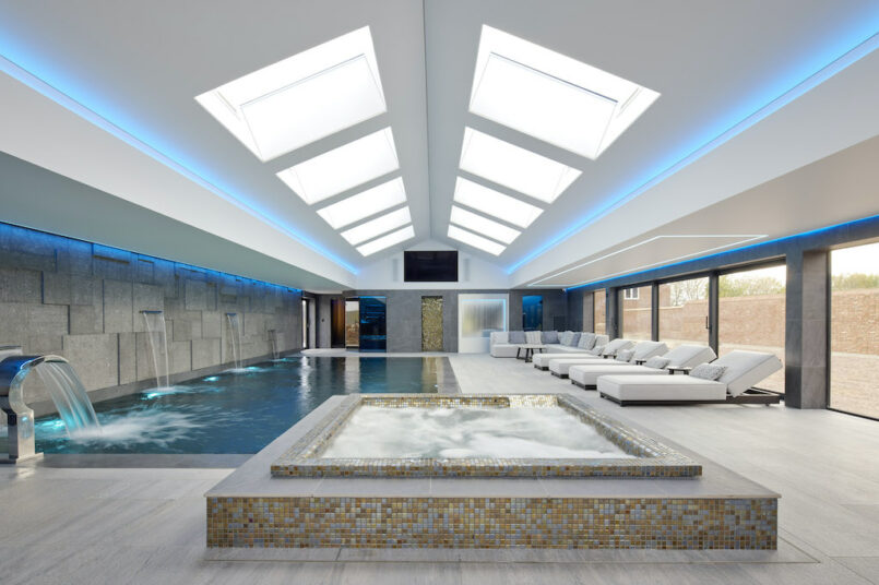 jacuzzi, swimming pool and several white indoor loungers at residential project